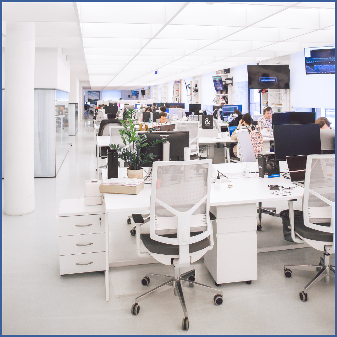 Office showing chairs and desks with people working on computers